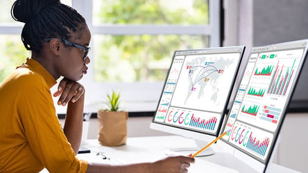 Woman using supply chain orchestration application to for manufacturing capacity planning